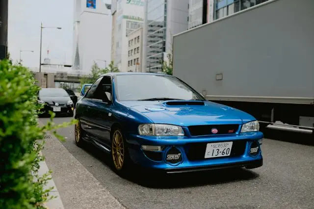 Blue Subaru sports car parked on a city street, showcasing its impressive Subaru performance history