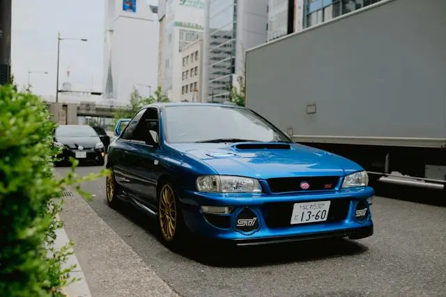 Blue Subaru sports car parked on a city street, showcasing its impressive Subaru performance history