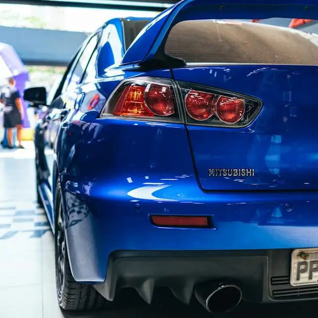Rear view of a blue Mitsubishi car showcasing the evolution of Mitsubishi cars design features