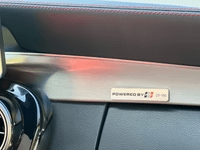 Close-up of TunerGenix PTG 1000 M177.2 Turbo System badge on car dashboard trim
